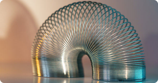 Close-up of a coiled metal spring with sufficiently high strength and elastic properties in neo light